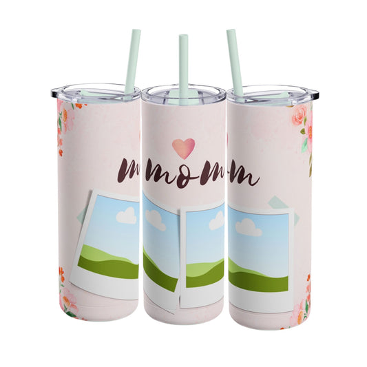 A set of three stainless steel tumblers with reusable straws and clear lids. The design features a soft pink background adorned with delicate floral accents in shades of pink and orange. The center tumbler displays the word "mom" in elegant script with a heart above it. Each tumbler includes placeholders for family photos, framed against a scenic backdrop of green hills, blue skies, and white clouds, creating a heartfelt and personalized theme perfect for moms.