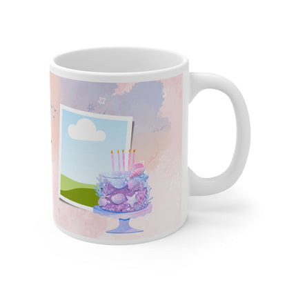 A white ceramic mug featuring a festive "Happy Birthday" design. The background is a soft pastel pink with watercolor-style splashes and subtle confetti accents. Above the "Happy Birthday" text in elegant blue script, there are colorful bunting flags in shades of pink, purple, and blue, adding a cheerful and celebratory touch to the mug's design.