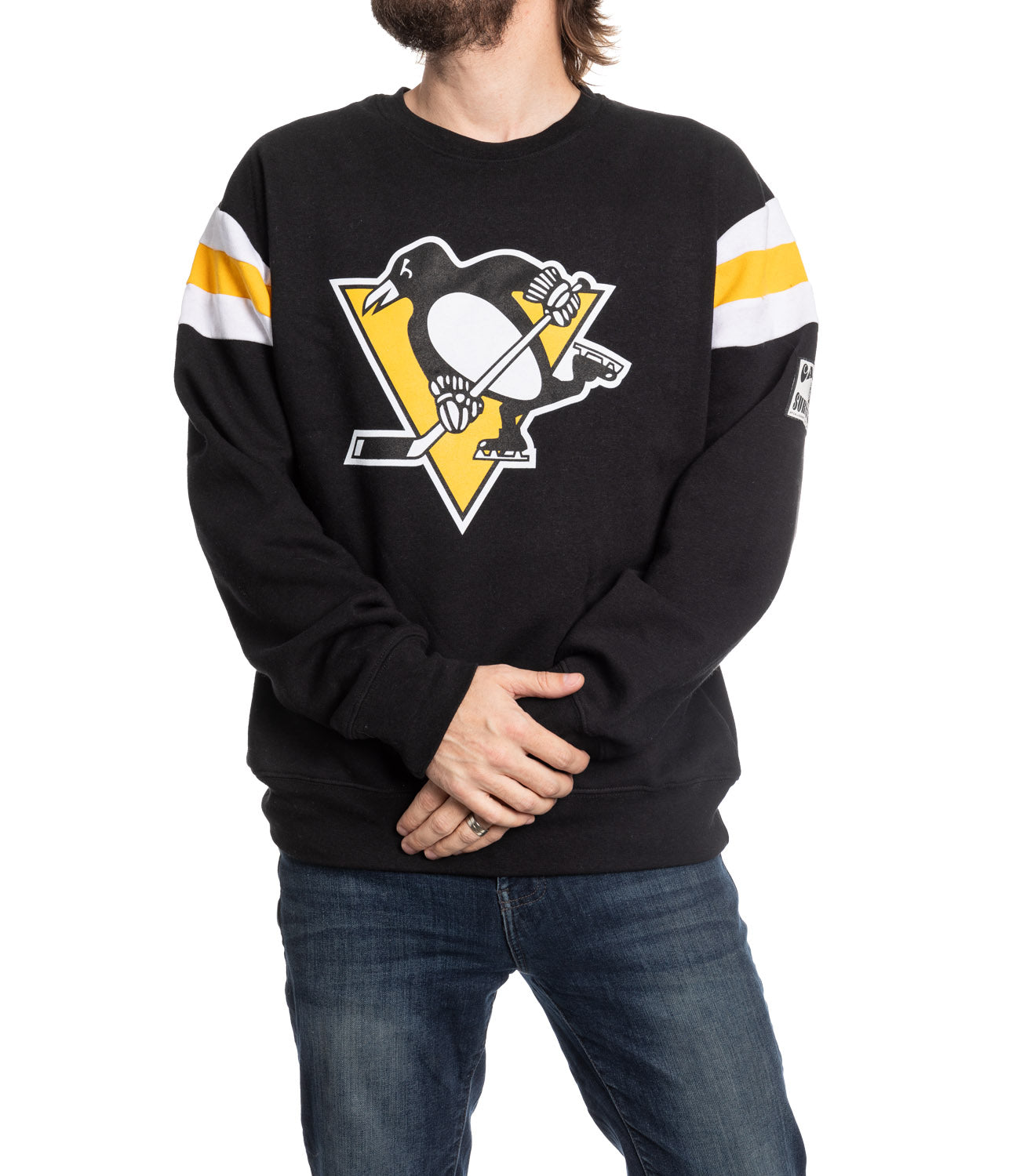 Person wearing a black sweater with a sports team logo on a white background