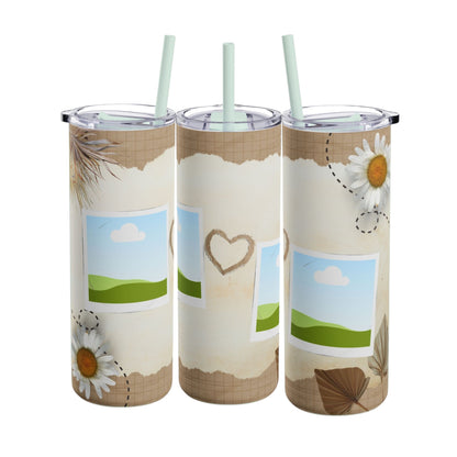 A set of three stainless steel tumblers with reusable straws and clear lids. The design features a rustic, textured beige background with grid elements and torn paper edges. Each tumbler includes placeholders for photos framed with a scenic backdrop of green hills, blue skies, and fluffy clouds. Delicate daisies, hand-drawn hearts, and dried leaves decorate the tumblers, adding a charming, nature-inspired touch perfect for personalization and gifting.