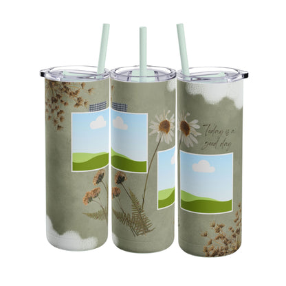 A set of three stainless steel tumblers with reusable straws and clear lids. The design features an earthy green background accented with subtle white paintbrush strokes. Each tumbler includes placeholders for scenic photos with green hills and blue skies. Hand-drawn wildflowers, daisies, and delicate ferns add a natural, rustic charm, while one tumbler features the uplifting phrase "Today is a good day" in elegant script. The design evokes a serene, nature-inspired theme perfect for personalization.